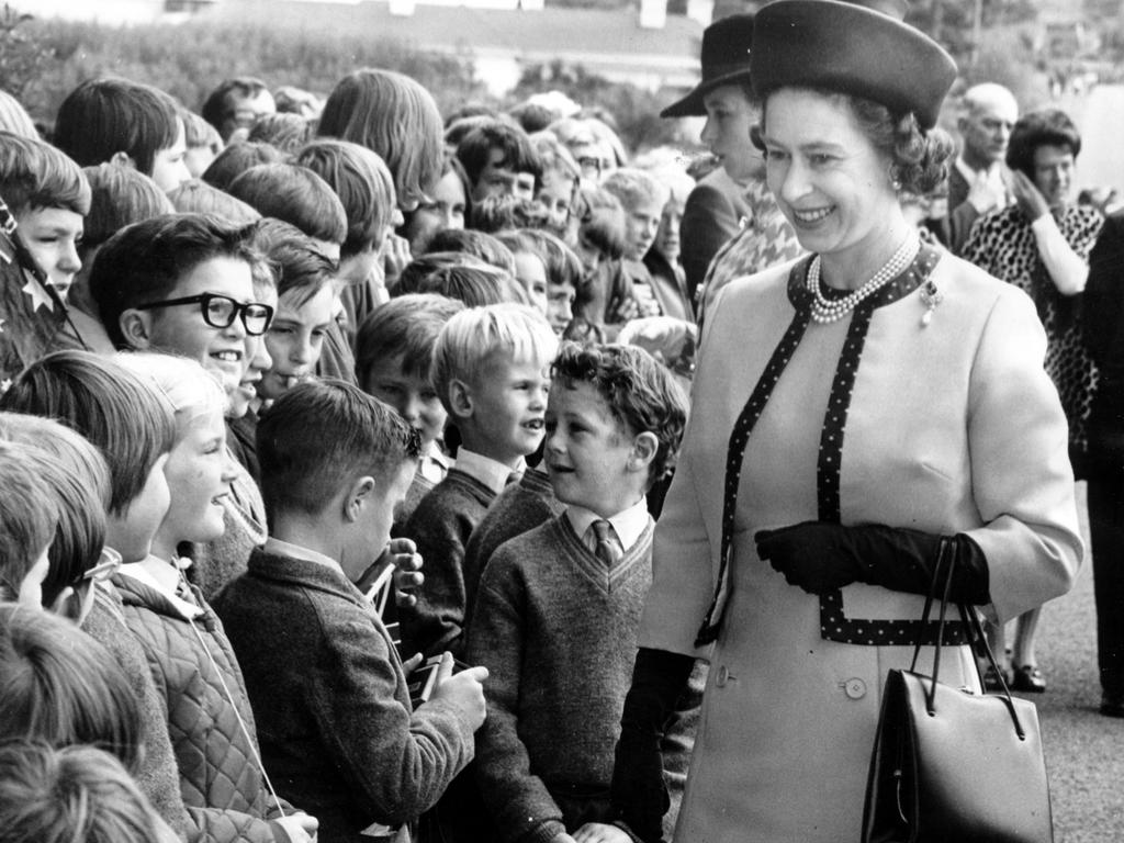 <b>1970 – Tasmania</b> The Queen’s 1970 visit to Australia introduced the Royal “walkabout”, a major break with tradition that allowed family members to meet and greet a larger number of people, not just officials and dignitaries. For this trip Down Under, the Queen – seen here meeting schoolchildren in Tasmania – was joined by Prince Philip, Prince Charles and Princess Anne, who reportedly shocked the crowd on one walkabout with a complaint about the “bloody wind”.