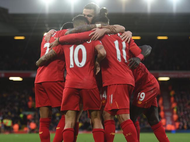 Liverpool's Senegalese midfielder Sadio Mane (R) celebrates scoring his team's fifth goal with Liverpool's Brazilian midfielder Philippe Coutinho (C) and Liverpool's Brazilian midfielder Roberto Firmino (2R) during the English Premier League football match between Liverpool and Watford at Anfield in Liverpool, north west England on November 6, 2016. / AFP PHOTO / PAUL ELLIS / RESTRICTED TO EDITORIAL USE. No use with unauthorized audio, video, data, fixture lists, club/league logos or 'live' services. Online in-match use limited to 75 images, no video emulation. No use in betting, games or single club/league/player publications. /