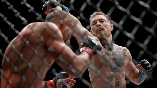 Conor McGregor punches Eddie Alvarez in their UFC lightweight championship fight at UFC 205.
