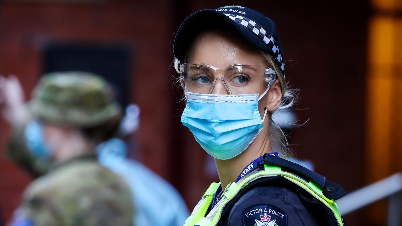 A police officer stands guard outside the InterContinental Hotel in Melbourne as returned travellers go into quarantine. Picture: Ian Currie