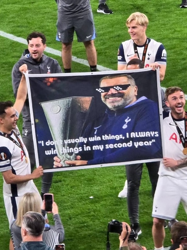 Tottenham's players hold up a banner with Postecoglou's famous quote.