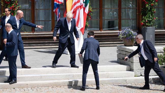 European Council president Charles Michel, left, helps direct Prime Minister Boris Johnson to his spot for the extended family photo of leaders from the G7 and partner countries. Picture: Getty Images