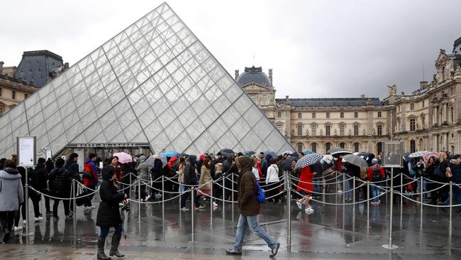 People wait to enter the Louvre in Paris a day after the machete attack.