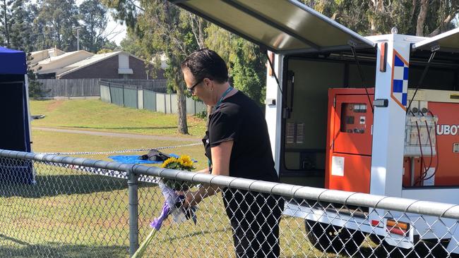 A woman, who gave her name as "Cathy" was the first to bring flowers to the location where Harrison Geppert died at Varsity Lakes. Picture: Annie Perets