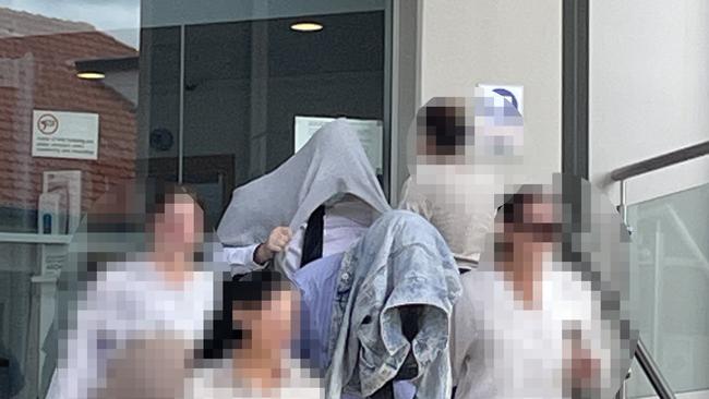 Mason John William Collins (back with head covered) and Brandon Charles Hixon (front with head covered), both 20, were sentenced on April 28 in Rockhampton District Court for their roles in the violent altercation at a Wandal residence on January 22, 2022.