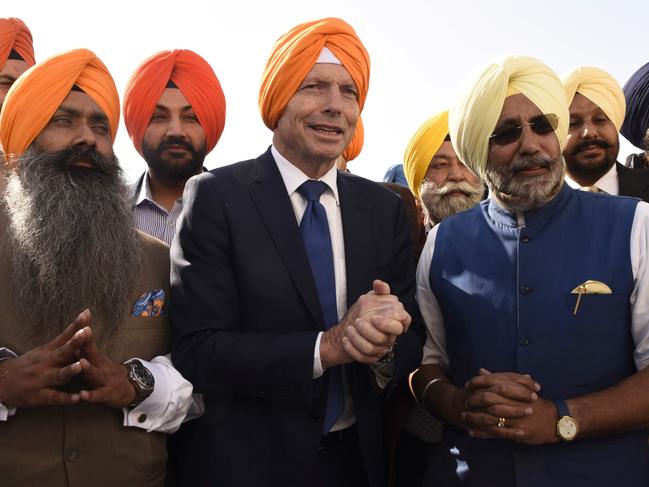 Former Australian Prime Minister Tony Abbott (C) pays his respect at the Golden Temple in Amritsar on November 17, 2019. (Photo by NARINDER NANU / AFP)