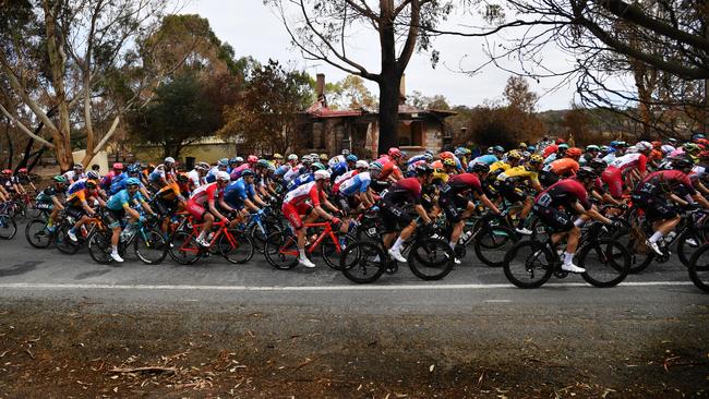 The garishly coloured peloton stood in stark contrast to the ash and black of the ruined countryside. Picture: AAP / David Mariuz