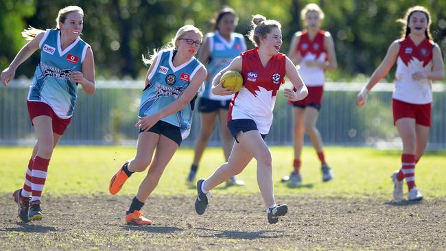 Mosman Swans and Drummoyne AFL players compete on the patchy surface of Middle Head Oval, Mosman in 2014.