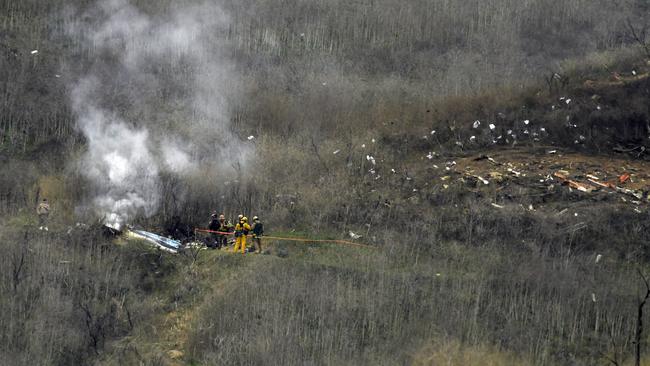 Firefighters work the scene of a helicopter crash. NBA basketball legend Kobe Bryant, his teenage daughter were among nine people killed in the crash in Southern California. Picture: AP PhotoMark J. Terrill