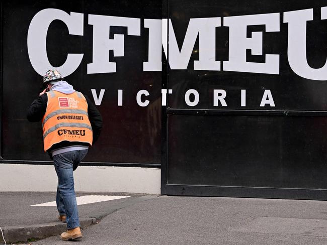 A union official walks past the Victorian headquarters of the Construction, Forestry and Maritime Employees Union (CFMEU) in Melbourne on July 17, 2024. Australia on July 17 pledged to clean up one of its most powerful trade unions, which has been tarred by accusations of intimidating "thuggery", corruption and cosy ties to organised crime. (Photo by William WEST / AFP)