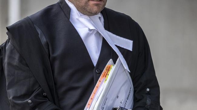 A barrister carries documents and a wig at the Supreme Court in Brisbane, Tuesday, October 29, 2019. (AAP Image/Glenn Hunt) NO ARCHIVING