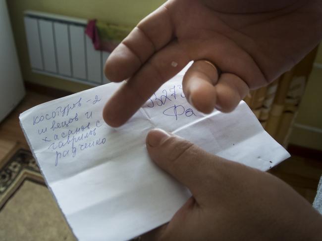 Yevgeny Berdyshev shows a list that residents of the village have compiled of the locals who are fighting in Syria, in Kedrovoye, Russia. Picture: AP