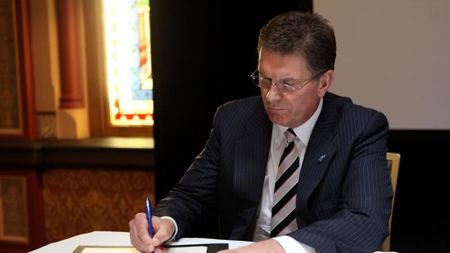 Ted Baillieu signs an official apology on behalf of the Victorian Government for past adoption practices. Picture: Paul Jeffers