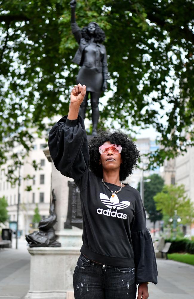 Jen Reid poses for a photograph in front of the sculpture. Picture: Matthew Horwood/Getty Images