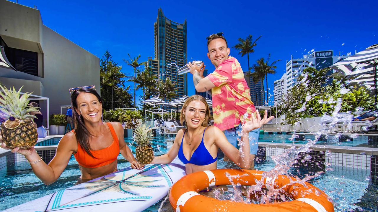 Vanessa Larkins and Tyra Eldridge poolside with QT Gold Coast’s cocktail king Brock Ashmore. Picture: NIGEL HALLETT