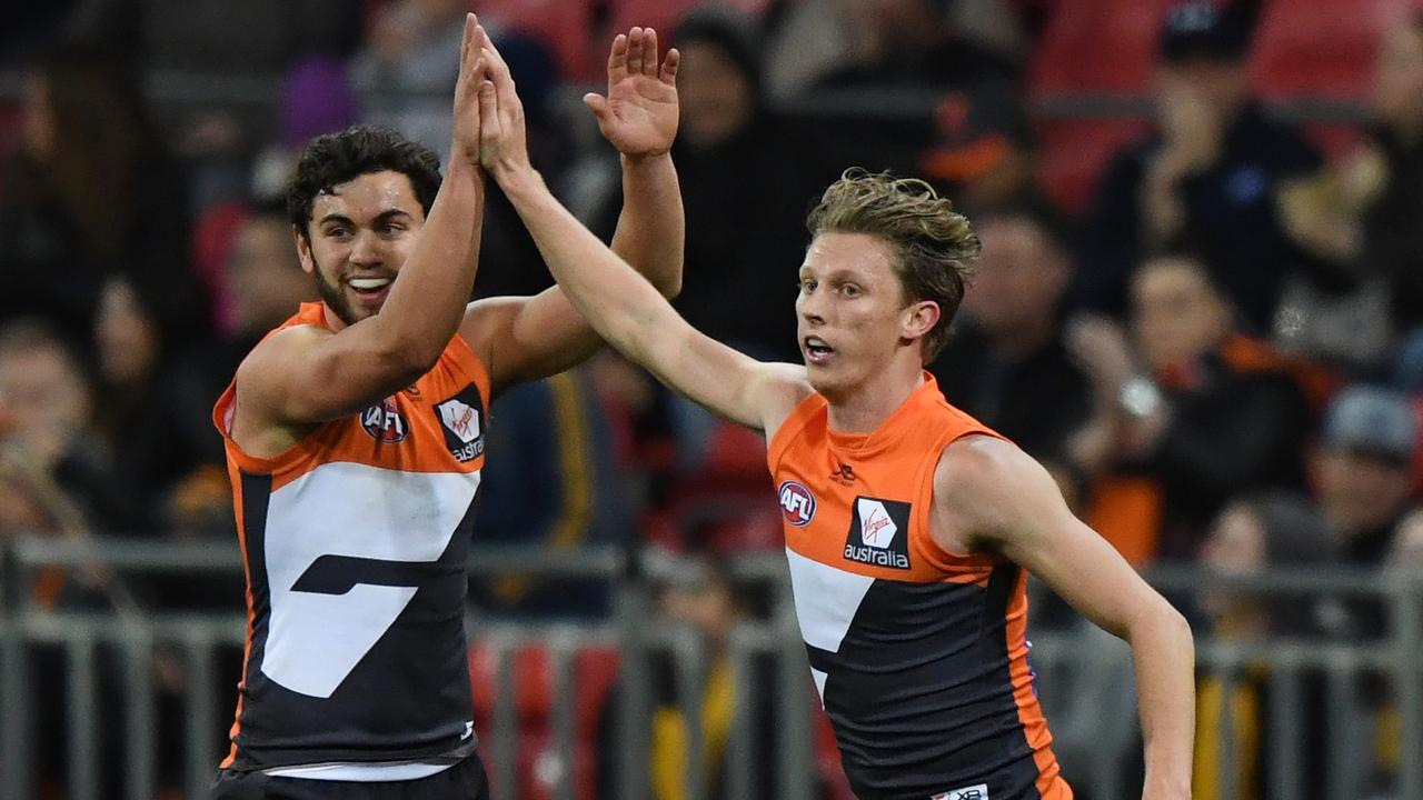 GWS’ Lachie Whitfield (right) celebrates after scoring a goal against Hawthorn. (AAP Image/David Moir)