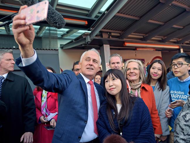 Australian Prime Minister Malcolm Turnbull and his wife Lucy takes selfies with locals during a street walk ahead of arriving at the Sunny Harbour Yum Cha in the federal seat of Barton in the Sydney suburb of Hurstville, Wednesday, June 29, 2016. A federal election will be held in Australia on Saturday July 2. (AAP Image/Lukas Coch)