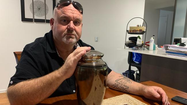 Brett Beasley sits with his son’s urn.