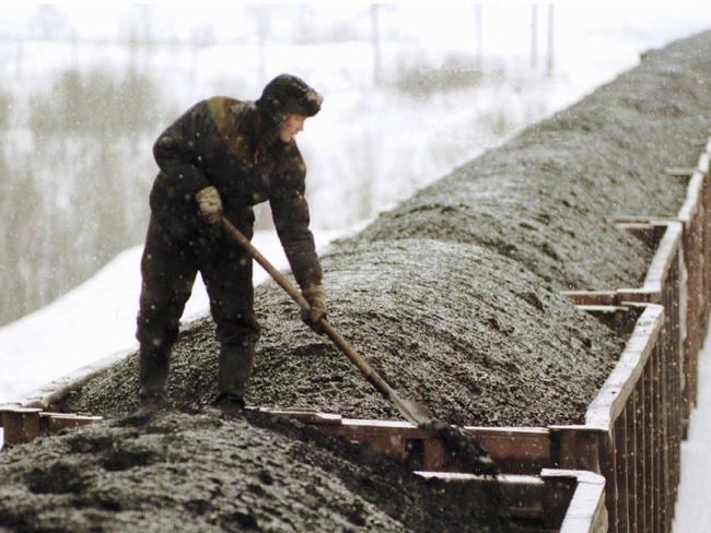 Worker smoothes carload coal prior to being freighted from mine near Novokuznetsk east of Moscow 03/02/96. Russian coal miners ended nationwide strike after government promised to pour money into industry, miners went on strike to press demands for back wages & other changes in their industry, still state-owned.                      Russia / Industry / Mining / Coal