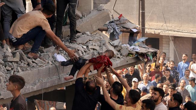 Rescuers pull a child out of the rubble of a building hit in an Israeli air strike in Khan Yunis in the southern Gaza Strip on October 24. Picture: AFP