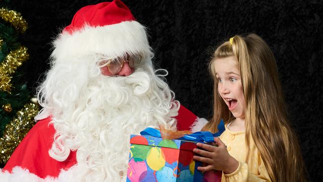 Santa with Avie Asimos, 6, at Actors Ink in Adelaide, where kids have been able to sit on Santa’s lap for the first time since Covid. Picture: Matt Loxton