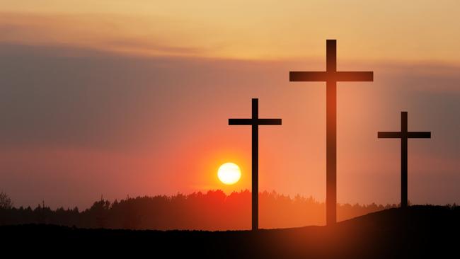 Christian cross on hill outdoors at sunrise. Resurrection of Jesus. Concept photo.