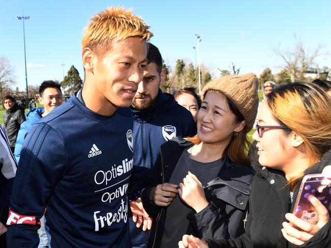 TOPSHOT - Japanese football player Keisuke Honda (L) greets fans after training for the first time with Melbourne Victory who are preparing for the start of Australia's A-League, in Melbourne on August 17, 2018. (Photo by William WEST / AFP)