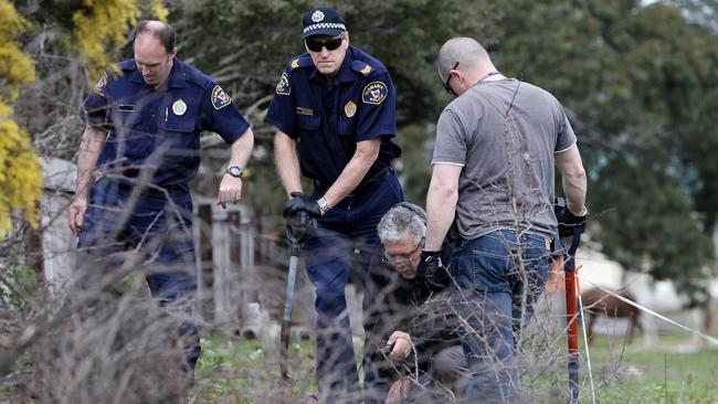 Tasmania Police search for bullet casings in the field adjacent to the residence where Shane Barker was murdered. Picture: LUKE BOWDEN