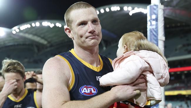 A shattered Sam Jacobs leaves Adelaide Oval with his daughter after his 200th game. Pic: SARAH REED