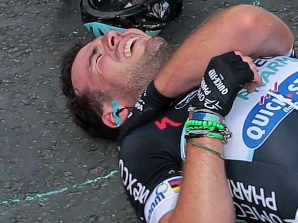 Britain's Mark Cavendish lies injured after a fall near the finish line at the end of the 190.5 km first stage of the 101st edition of the Tour de France cycling race on July 5, 2014 between Leeds and Harrogate, northern England. The 2014 Tour de France gets underway on July 5 in the streets of Leeds and ends on July 27 down the Champs-Elysees in Paris. AFP PHOTO / POOL / FRED MONS