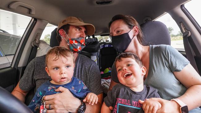 Dave Rosier and Kim Cullen with their children Sean, 9 months and Hugh, 2, were among the Victorians who rushed home from NSW. Picture: Simon Dallinger