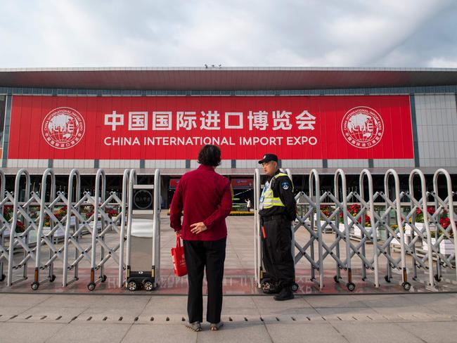 A security guard stands in front of the entrance of the National Exhibition and Convention Center (Shanghai), the main venue to hold the upcoming first China International Import Expo (CIIE), is seen in Shanghai on October 31, 2018. - Chinese President Xi Jinping opens a huge Shanghai import fair next week at which armies of Chinese companies will shop for billions of dollars in foreign goods as China seeks to counter charges that its markets aren't open. (Photo by Johannes EISELE / AFP)