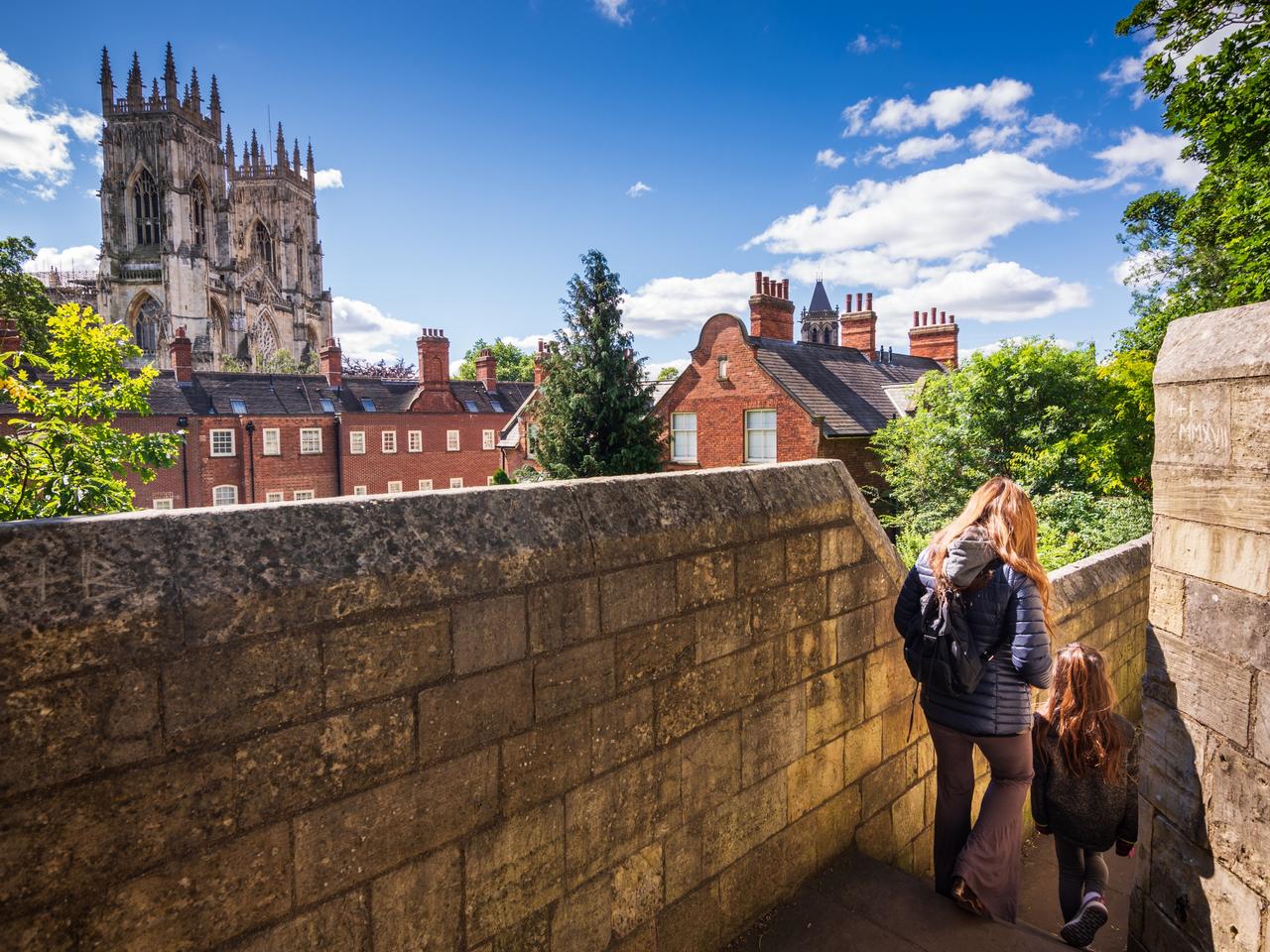 Tourists walking along York's city walls in England
