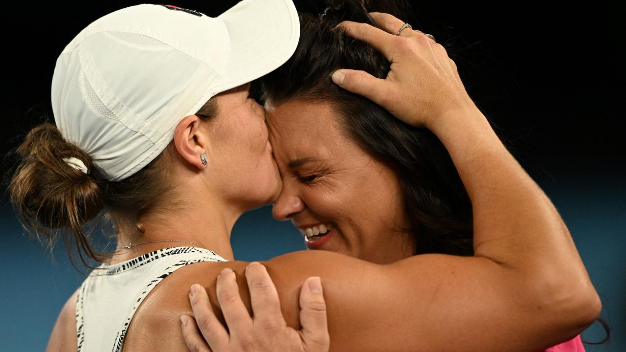 Ashleigh Barty kisses friend and doubles partner Casey Dellacqua on the forehead. Photo by MICHAEL ERREY / AFP.