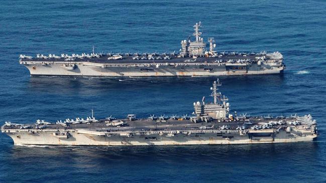 Aircraft carriers USS Ronald Reagan, bottom, and USS Nimitz.