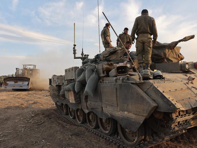 Israeli troops gather near the border with Gaza before entering the Palestinian strip. Picture: AFP