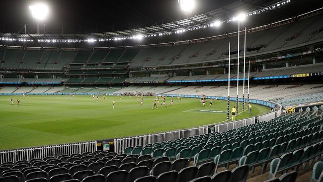 MELBOURNE, AUSTRALIA - MARCH 19: Players compete for the ball as empty seats are seen due to the coronavirus outbreak during the 2020 AFL Round 01 match between the Richmond Tigers and the Carlton Blues at the Melbourne Cricket Ground on March 19, 2020 in Melbourne, Australia. (Photo by Michael Willson/AFL Photos via Getty Images)