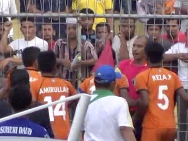 Players clash with the referee after the shocking tackle.