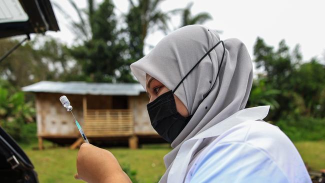 A nurse prepares a dose of the Pfizer vaccine for a group of villagers in Pos Simpor, a village and settlement of Orang Asli (indigenous Malaysians) in the district of Gua Musang, Kelantan, Malaysia. Picture: Annice Lyn/Getty Images