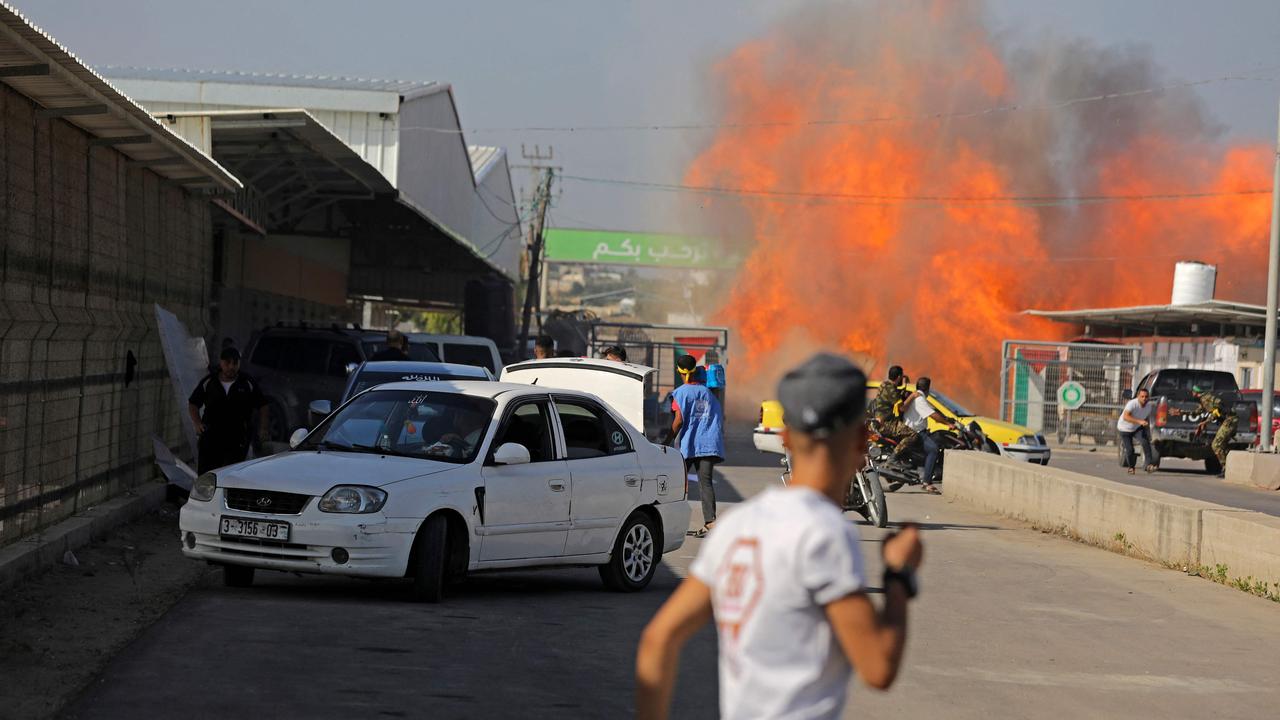 Palestinians and militants from the Ezzedine al-Qassam Brigades run towards the Erez crossing between Israel and the northern Gaza Strip. Picture: AFP