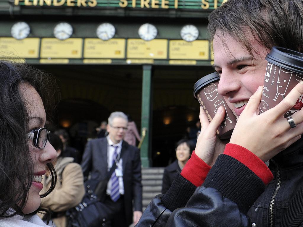 Cold weather on a Melbourne morning. Ruby Falkland warms her friend Jacob Canteri with cups of coffee.