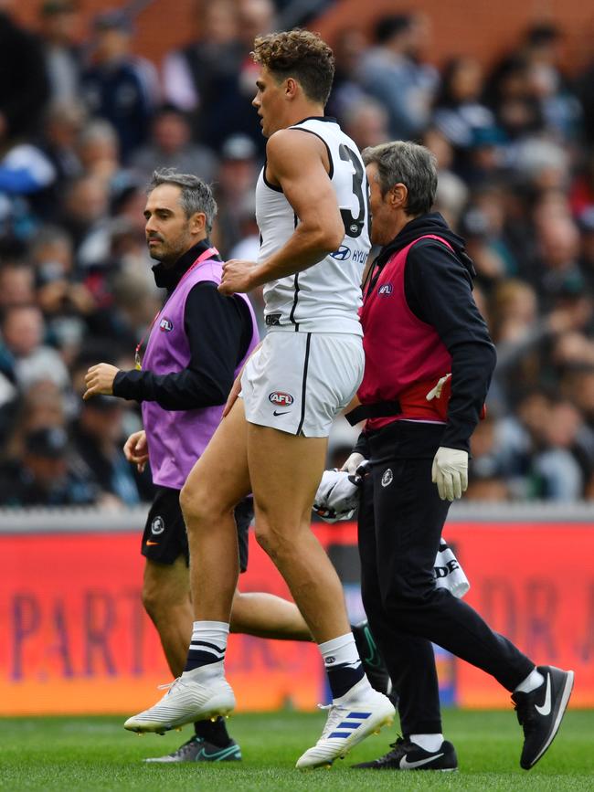 Charlie Curnow limps from the field after injuring his knee. Picture: AAP Image/David Mariuz. 