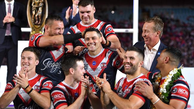 Cooper Cronk celebrates with teammates and coach Trent Robinson after winning the 2019 grand final.