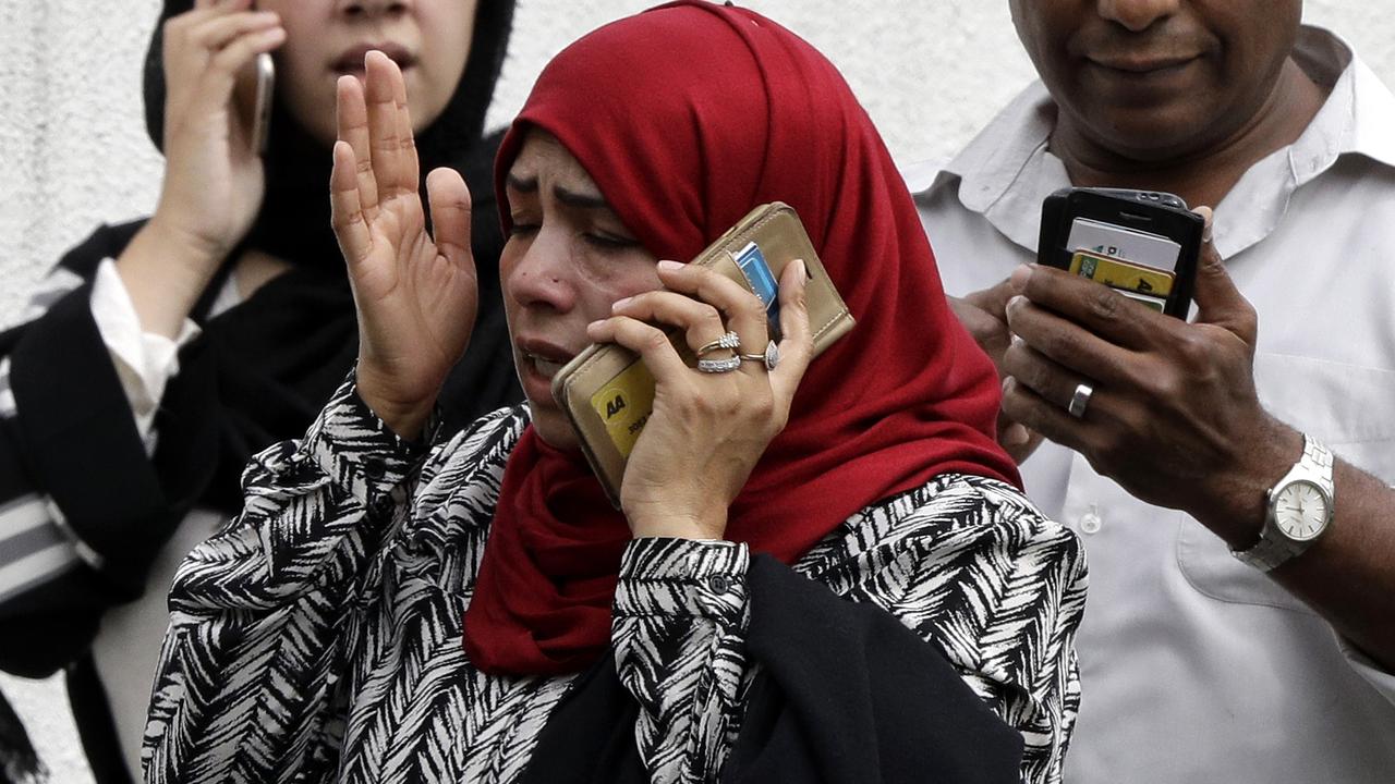 People wait outside a mosque in central Christchurch, New Zealand, Friday, March 15, 2019. Many people were killed in a mass shooting at a mosque in the New Zealand city of Christchurch on Friday, a witness said. Police have not yet described the scale of the shooting but urged people in central Christchurch to stay indoors. (AP Photo/Mark Baker)