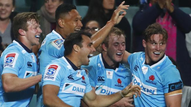 Waratahs players celebrate an Israel Folau try on Saturday night.