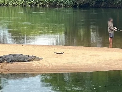 A British expat caught this hair-raising image of an Aussie fisherman fishing just metres from a saltwater croc. Picture: Supplied.