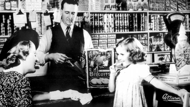 A young child tries an Arnott's Milk Arrowroot biscuit in a grocery shop in the 1940s.