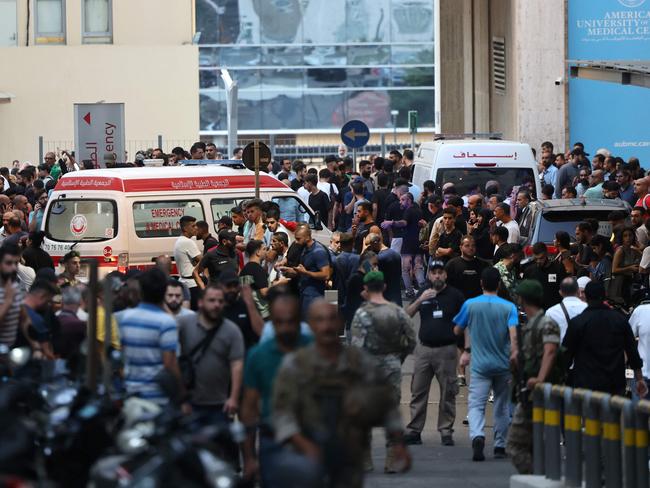 Ambulances are surrounded by people at the entrance of the American University of Beirut Medical Center, on September 17, 2024, after explosions hit locations in several Hezbollah strongholds around Lebanon amid ongoing cross-border tensions between Israel and Hezbollah fighters. Hundreds of people were wounded when Hezbollah members' paging devices exploded simultaneously across Lebanon on September 17, in what a source close to the militant movement said was an "Israeli breach" of its communications. (Photo by ANWAR AMRO / AFP)