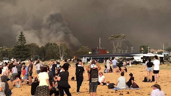 Evacuees take cover at Malua Bay after fire tore through the small town on New Year’s Eve, 2019. Picture: Al Baxter