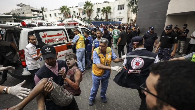 A Palestinian carries a wounded boy rescued from the rubble after an Israeli air strike on Gaza City. Picture: Sameh Rahmi/NurPhoto via Getty Images